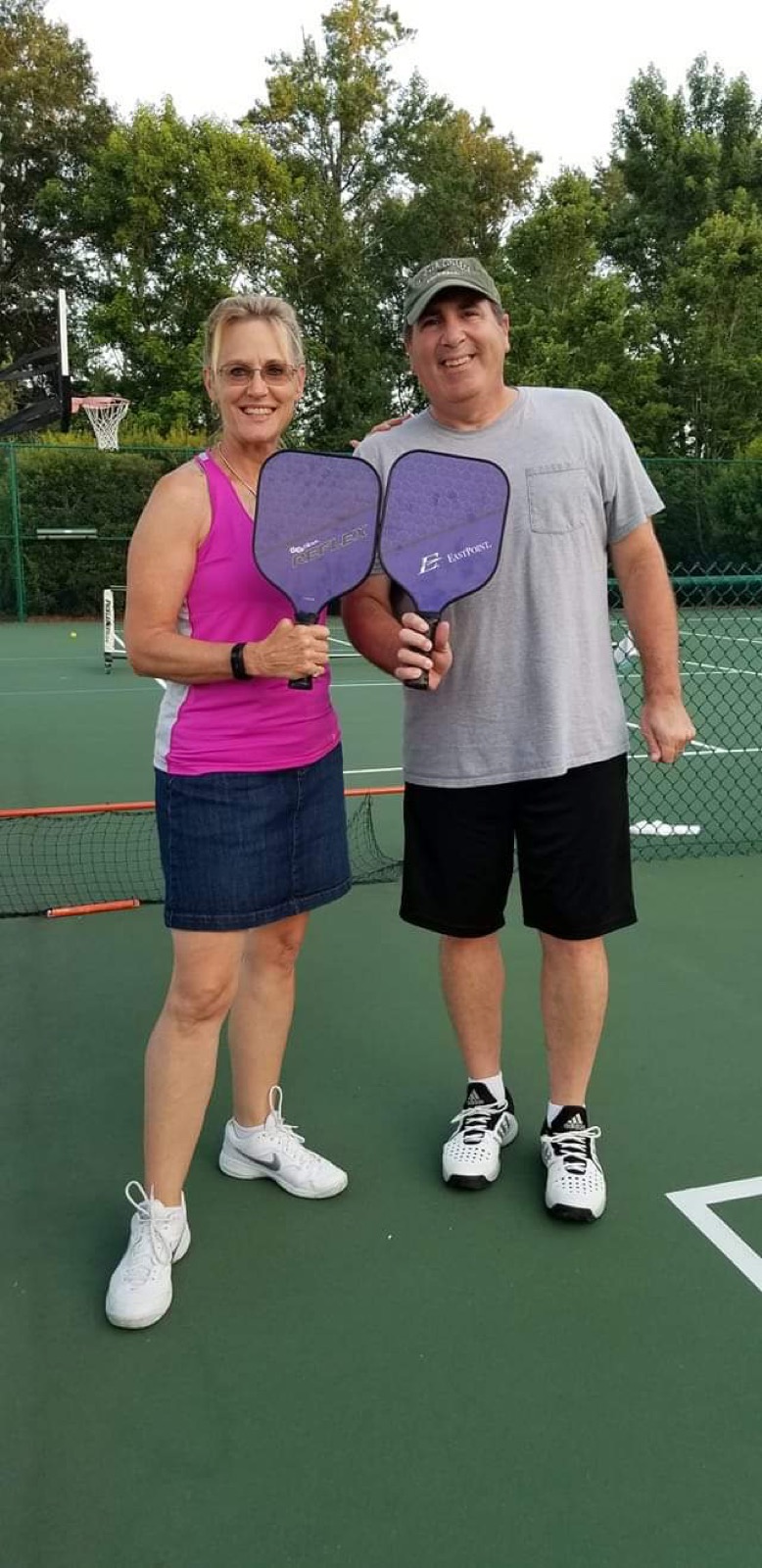 Karen Koehler-Cesa and her husband on a pickleball court with paddles